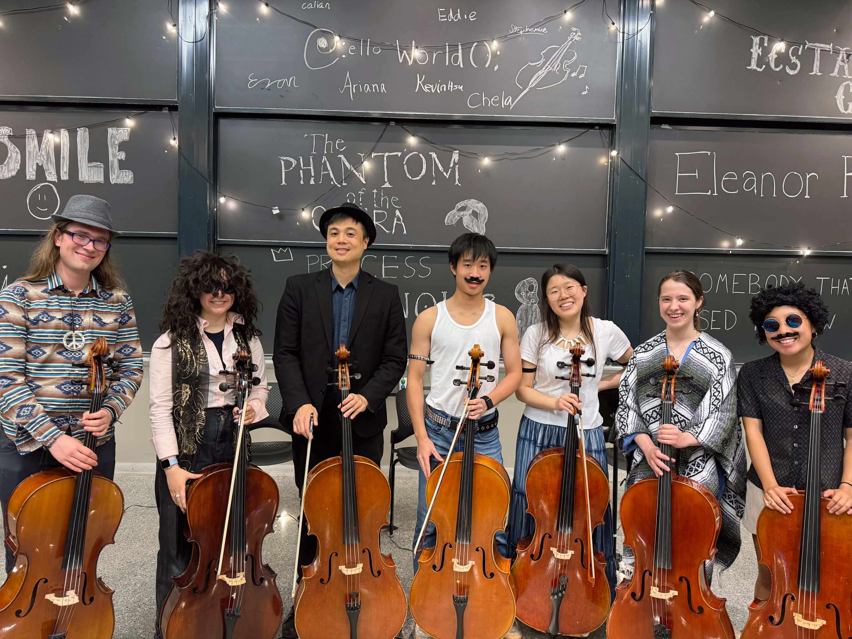 Costumed celloworld members stand holding their cellos after the Spring 2025 showcase.